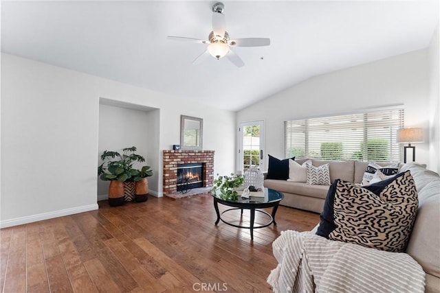 living area featuring baseboards, a ceiling fan, hardwood / wood-style floors, vaulted ceiling, and a fireplace