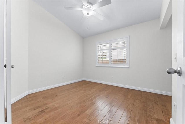 spare room with baseboards, lofted ceiling, hardwood / wood-style flooring, and a ceiling fan