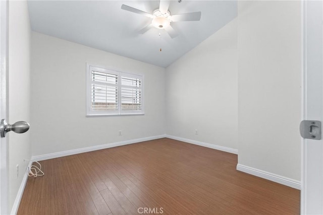 spare room with a ceiling fan, lofted ceiling, baseboards, and wood finished floors