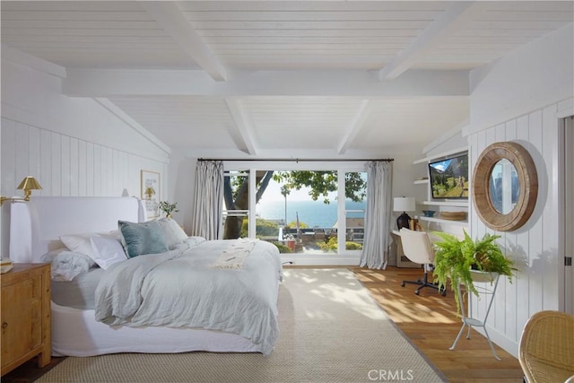 bedroom with vaulted ceiling with beams and wood finished floors