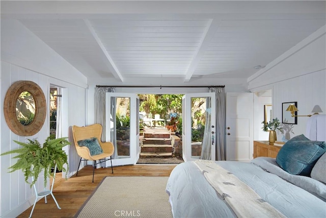 bedroom with access to exterior, vaulted ceiling with beams, and wood finished floors