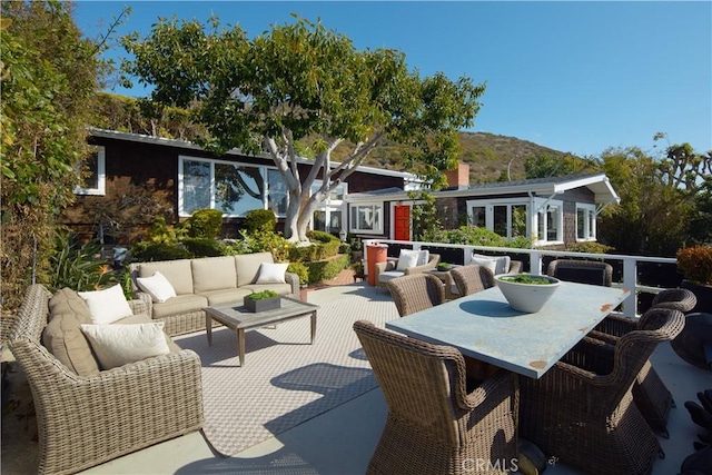 view of patio with a mountain view, an outdoor living space, and outdoor dining space