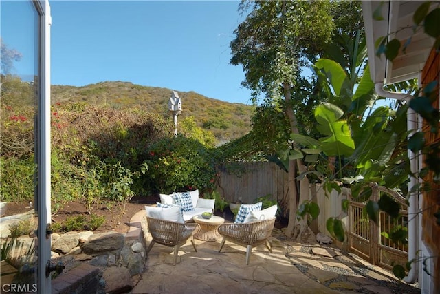 view of patio / terrace with a mountain view, an outdoor hangout area, and fence