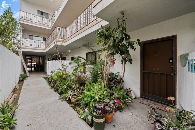 property entrance featuring fence and stucco siding