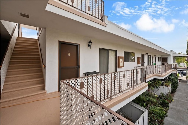 property entrance with visible vents and stucco siding