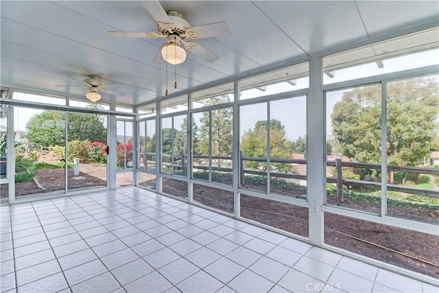 unfurnished sunroom with a ceiling fan and a healthy amount of sunlight