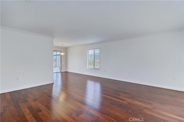 unfurnished room featuring crown molding, baseboards, and hardwood / wood-style flooring