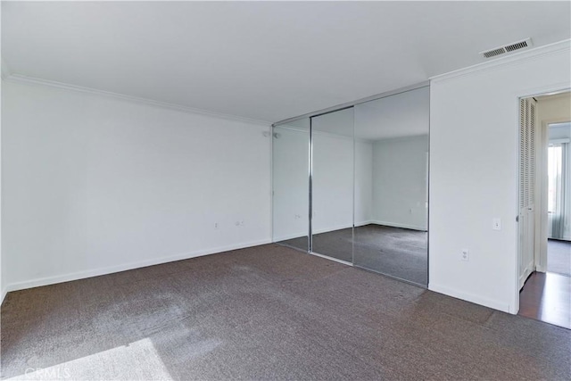 unfurnished bedroom with ornamental molding, carpet, visible vents, and baseboards