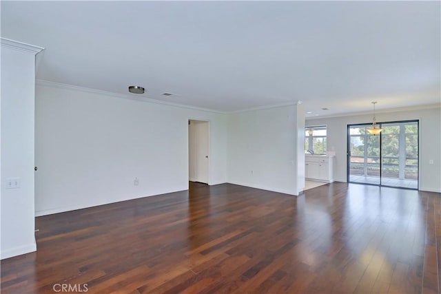 empty room featuring baseboards, dark wood-type flooring, and crown molding