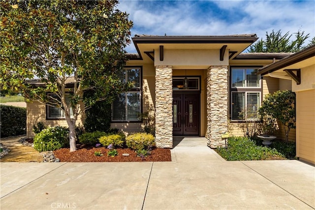 entrance to property with stone siding and stucco siding