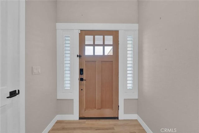 foyer with light wood-type flooring and baseboards