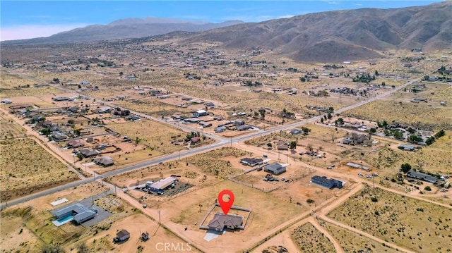 drone / aerial view featuring view of desert, a rural view, and a mountain view