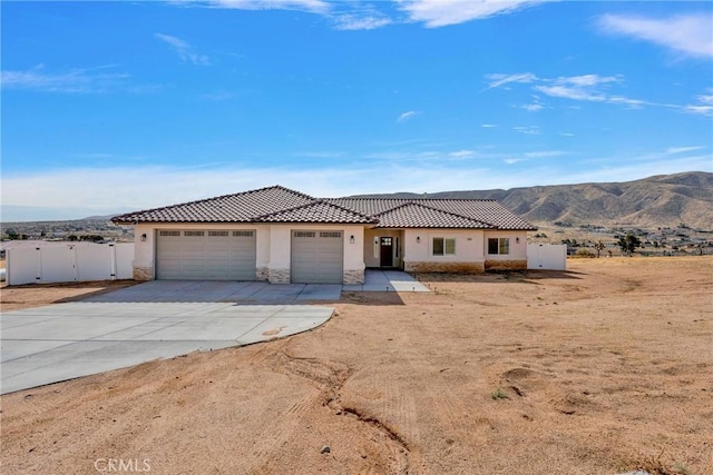 view of front of house with concrete driveway, a tiled roof, an attached garage, and stucco siding