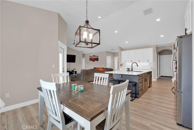 dining room with a chandelier, recessed lighting, light wood-style flooring, and baseboards