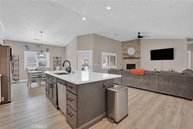 kitchen featuring light countertops, appliances with stainless steel finishes, a sink, and light wood-style floors