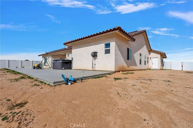 back of house with a patio area, a tiled roof, fence, and stucco siding