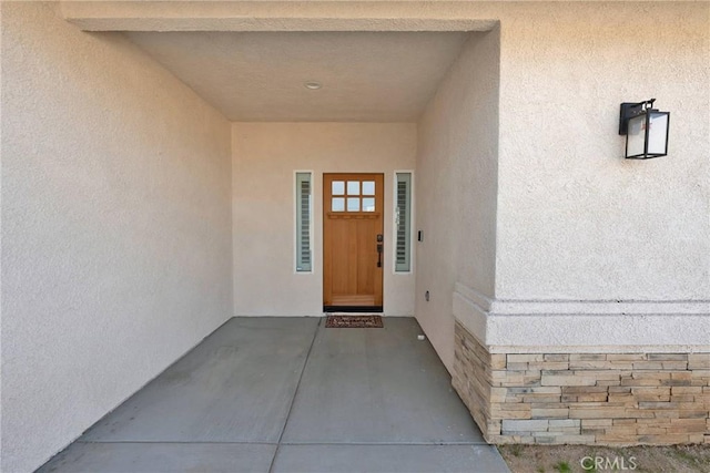 view of exterior entry featuring stucco siding