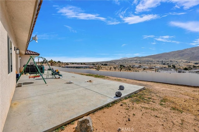 view of patio / terrace featuring fence and a mountain view