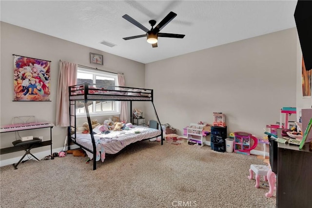 carpeted bedroom featuring a ceiling fan, visible vents, and baseboards