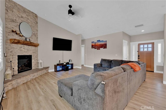 living area with a fireplace, wood finished floors, and baseboards