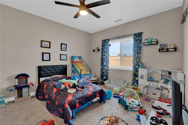 carpeted bedroom featuring a ceiling fan, visible vents, and baseboards