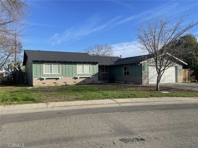 view of front facade featuring a garage, concrete driveway, board and batten siding, and a front yard