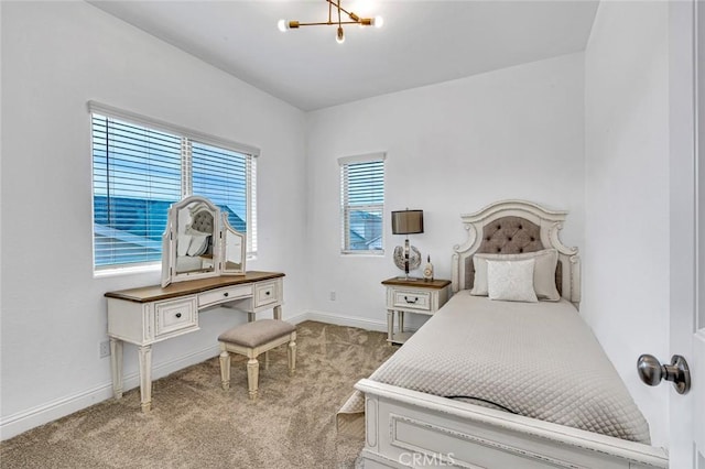 carpeted bedroom with baseboards and a chandelier