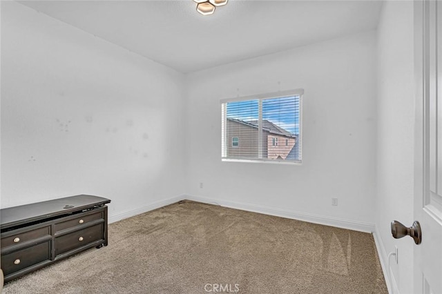 spare room with carpet and baseboards