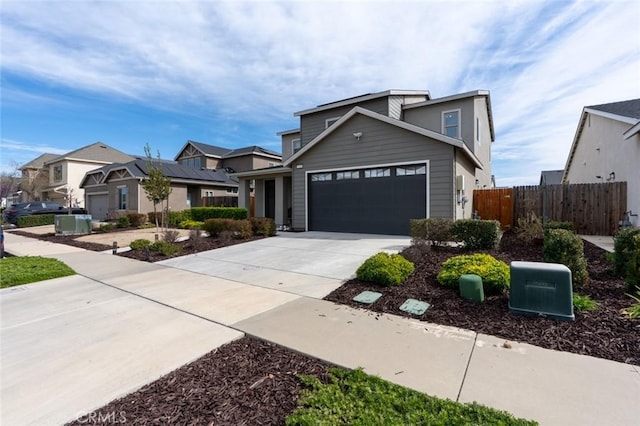 traditional home with driveway, an attached garage, and fence