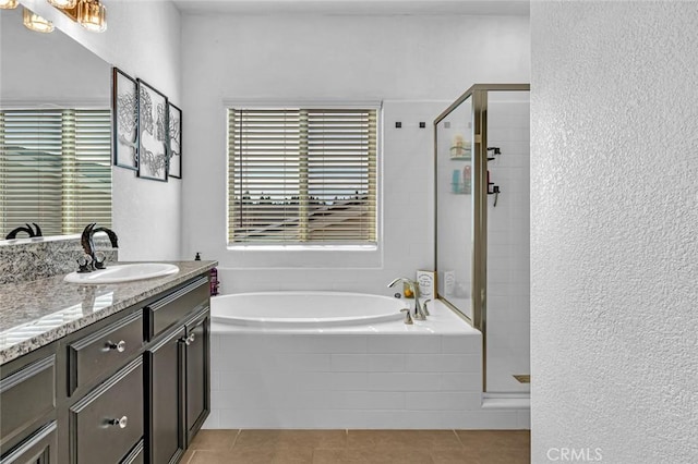 full bathroom with a stall shower, tile patterned floors, a bath, and vanity