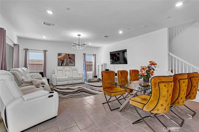 living area featuring a healthy amount of sunlight, an inviting chandelier, and visible vents