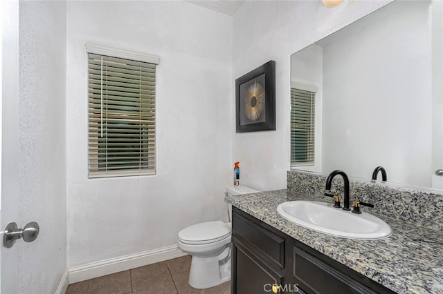 bathroom featuring vanity, tile patterned flooring, toilet, and baseboards