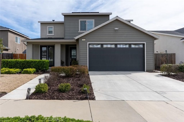 traditional-style home featuring driveway, a garage, and fence