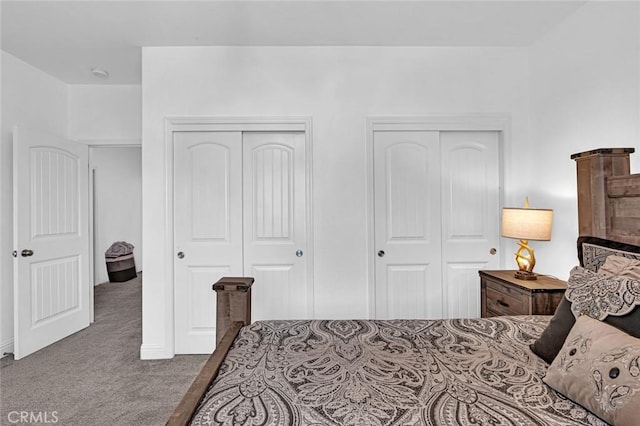 carpeted bedroom featuring two closets