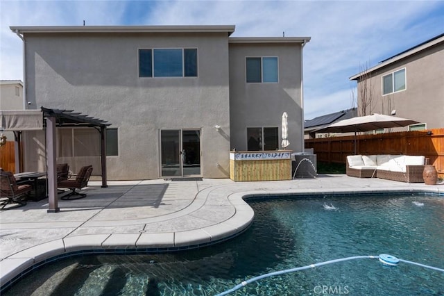 rear view of property featuring an outdoor hangout area, fence, stucco siding, a pergola, and a patio area