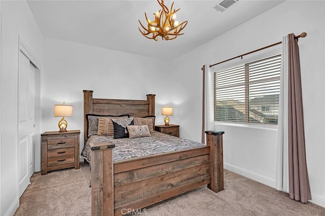 carpeted bedroom featuring a chandelier, visible vents, and baseboards