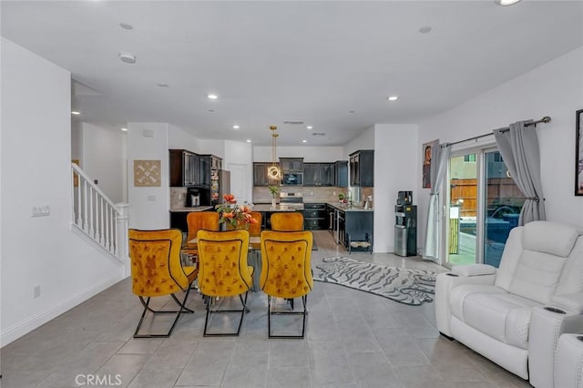 dining room with light tile patterned floors, stairs, baseboards, and recessed lighting