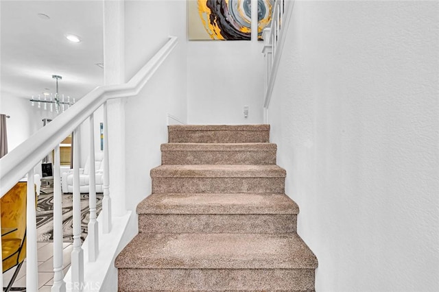 staircase with an inviting chandelier