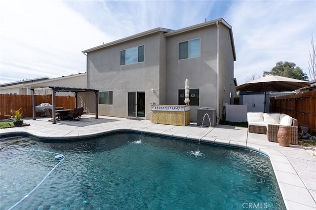 rear view of house with stucco siding, a patio area, a fenced backyard, and a pergola