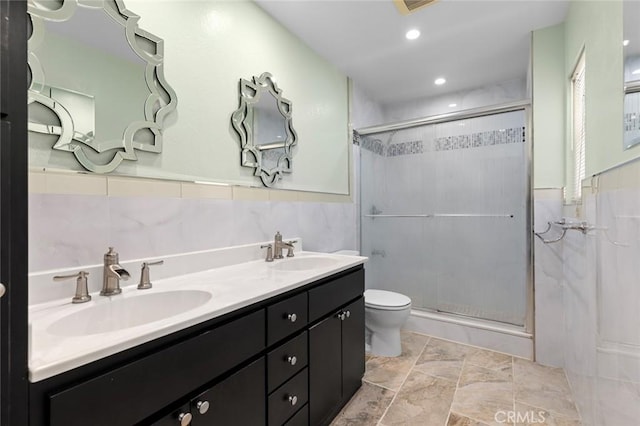 full bath featuring a sink, a shower stall, and toilet