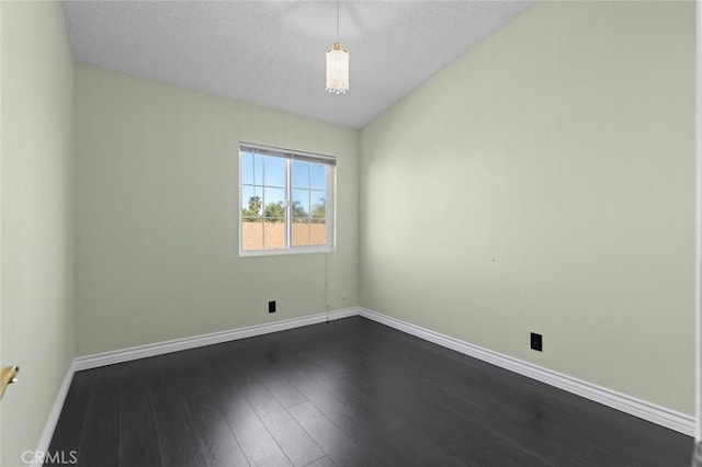 unfurnished room with dark wood-style floors, a textured ceiling, and baseboards