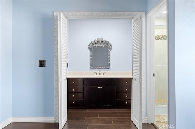 full bathroom with baseboards, vanity, and wood tiled floor