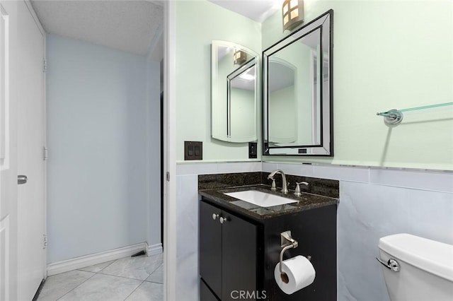 bathroom featuring tile walls, toilet, wainscoting, vanity, and tile patterned flooring