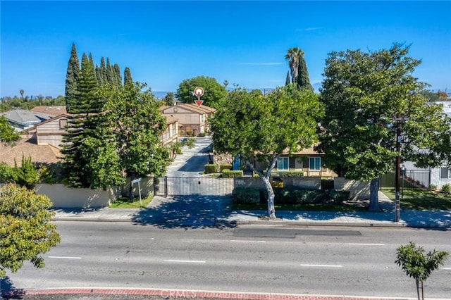 view of property hidden behind natural elements with a fenced front yard