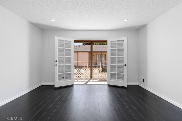 unfurnished room with recessed lighting, dark wood finished floors, a textured ceiling, and baseboards