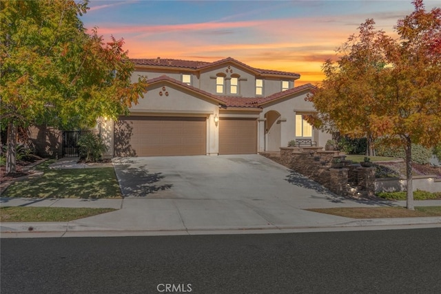 25499 Foxglove Ln, Corona, CA 92883 - mediterranean / spanish-style house with concrete driveway, an attached garage, a tiled roof, and stucco siding