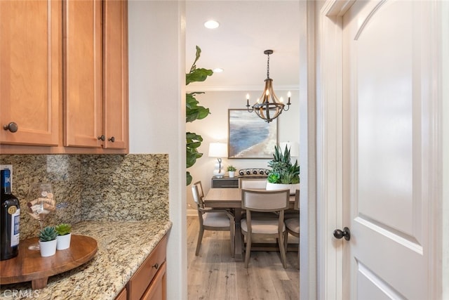25499 Foxglove Ln, Corona, CA 92883 - interior space featuring a notable chandelier, backsplash, light wood-style floors, light stone counters, and decorative light fixtures