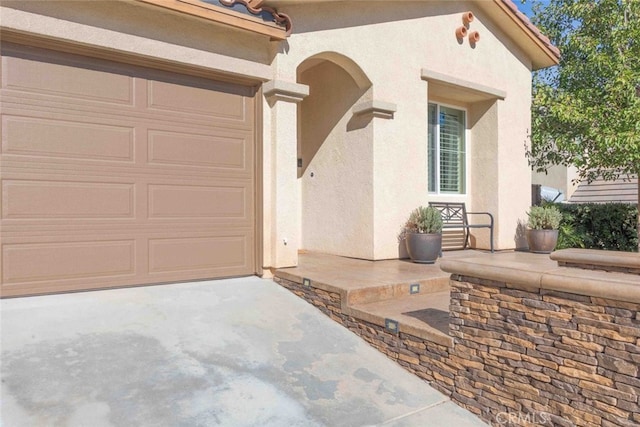 25499 Foxglove Ln, Corona, CA 92883 - doorway to property with an attached garage, concrete driveway, and stucco siding