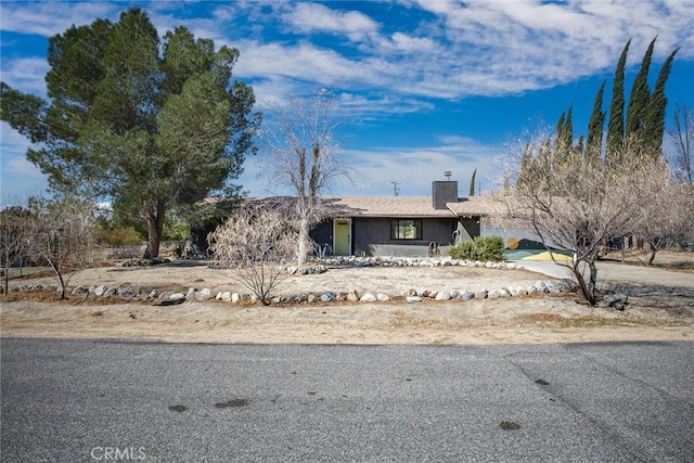 view of front of home featuring a garage, driveway, and a chimney