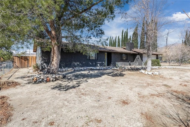 single story home with a garage, a chimney, and fence